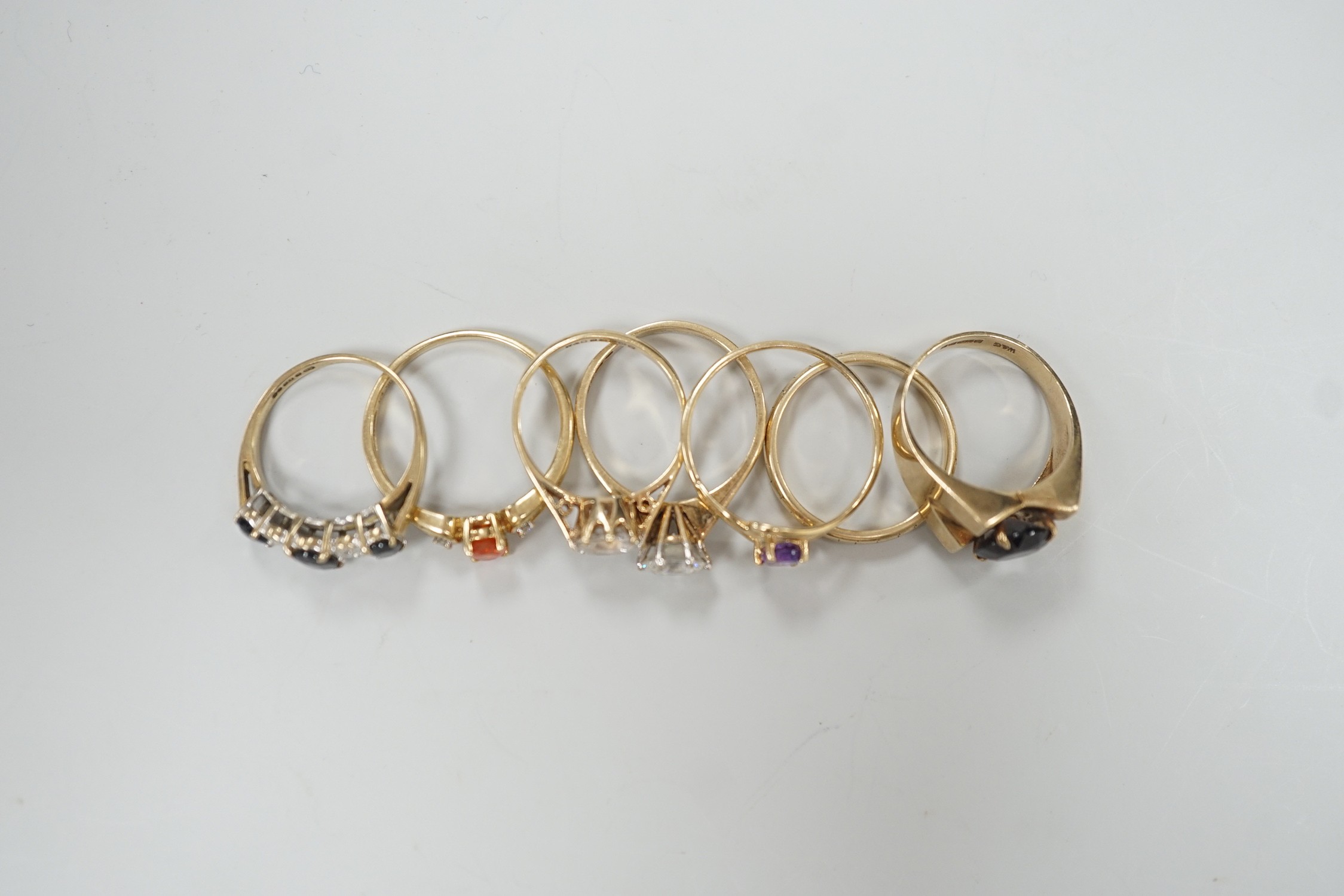 Six assorted modern 9ct gold and gem set rings, including amethyst and garnet single stone rings, together with a 9ct gold wedding band, gross weight 15.2 grams.